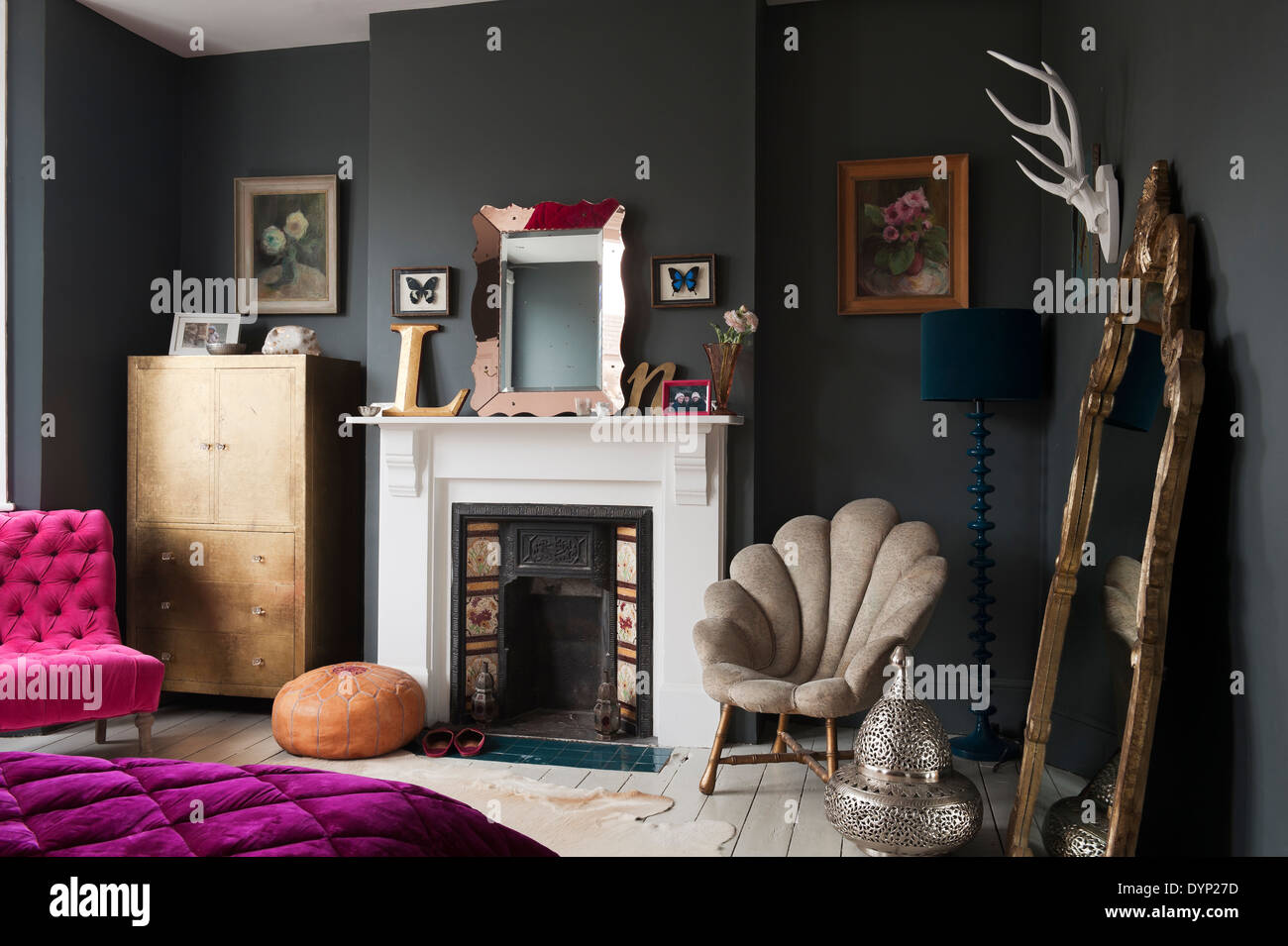 Dark painted bedroom with assorted vintage and Graham and Green furniture. Stock Photo