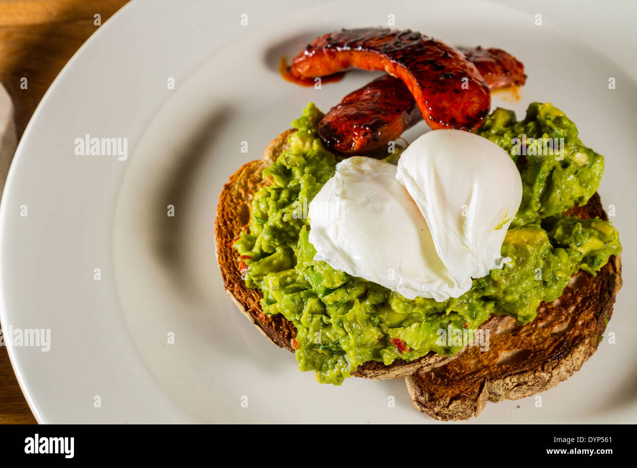 Poached eggs and Spanish spicy chorizo sausage on a bed of avocado on