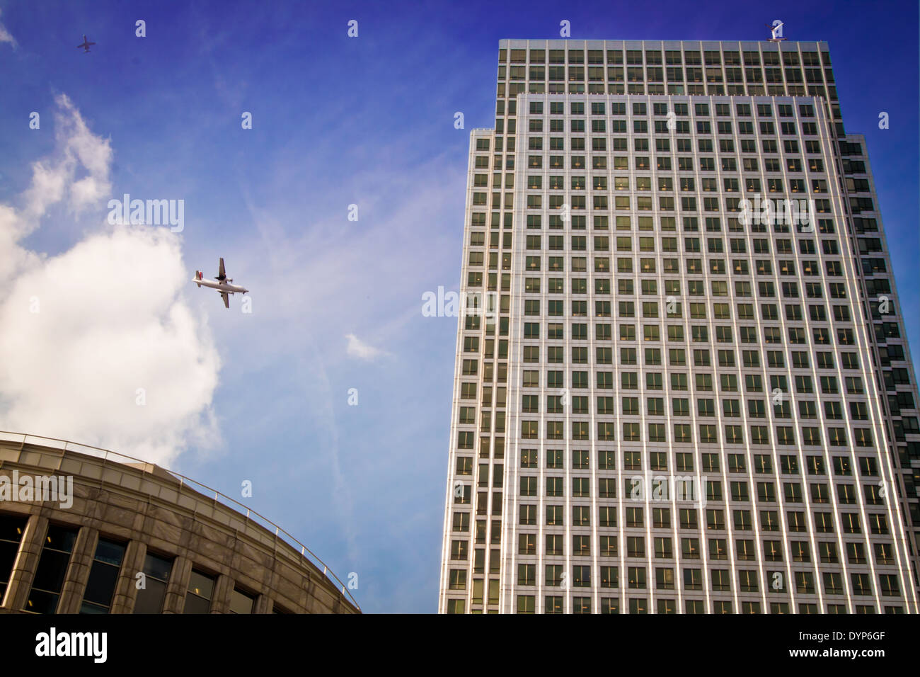 Two planes flying by the One Canada Square skyscraper in the new financial district of Canary Wharf, London, UK. Stock Photo