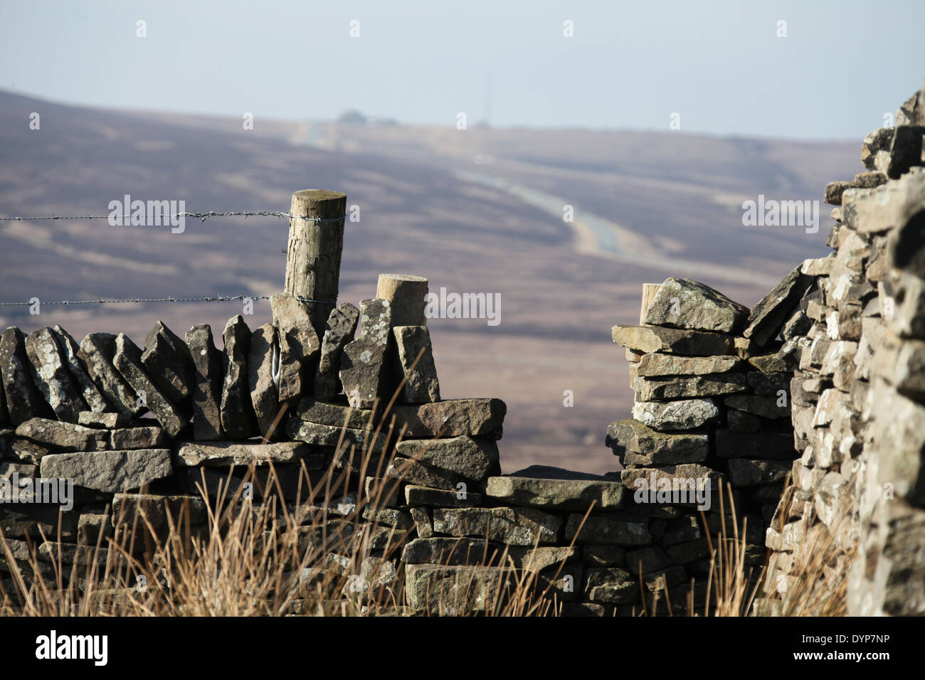 Stile over drystone wall at Axe Edge in the Peak District National Park with the Cat and Fiddle Pub on the A537 in the distance Stock Photo