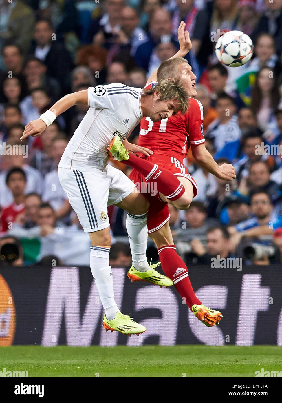 Madrid, Spain. 23rd Apr, 2014. Defender Fabio Coentrao of Real Madrid (L) duels for a high ball with Bastian SCHWEINSTEIGER during the UEFA Champions League Game between Real Madrid and FC Bayern Munich at Santiago Bernabeu Stadium, Valencia Credit:  Action Plus Sports/Alamy Live News Stock Photo