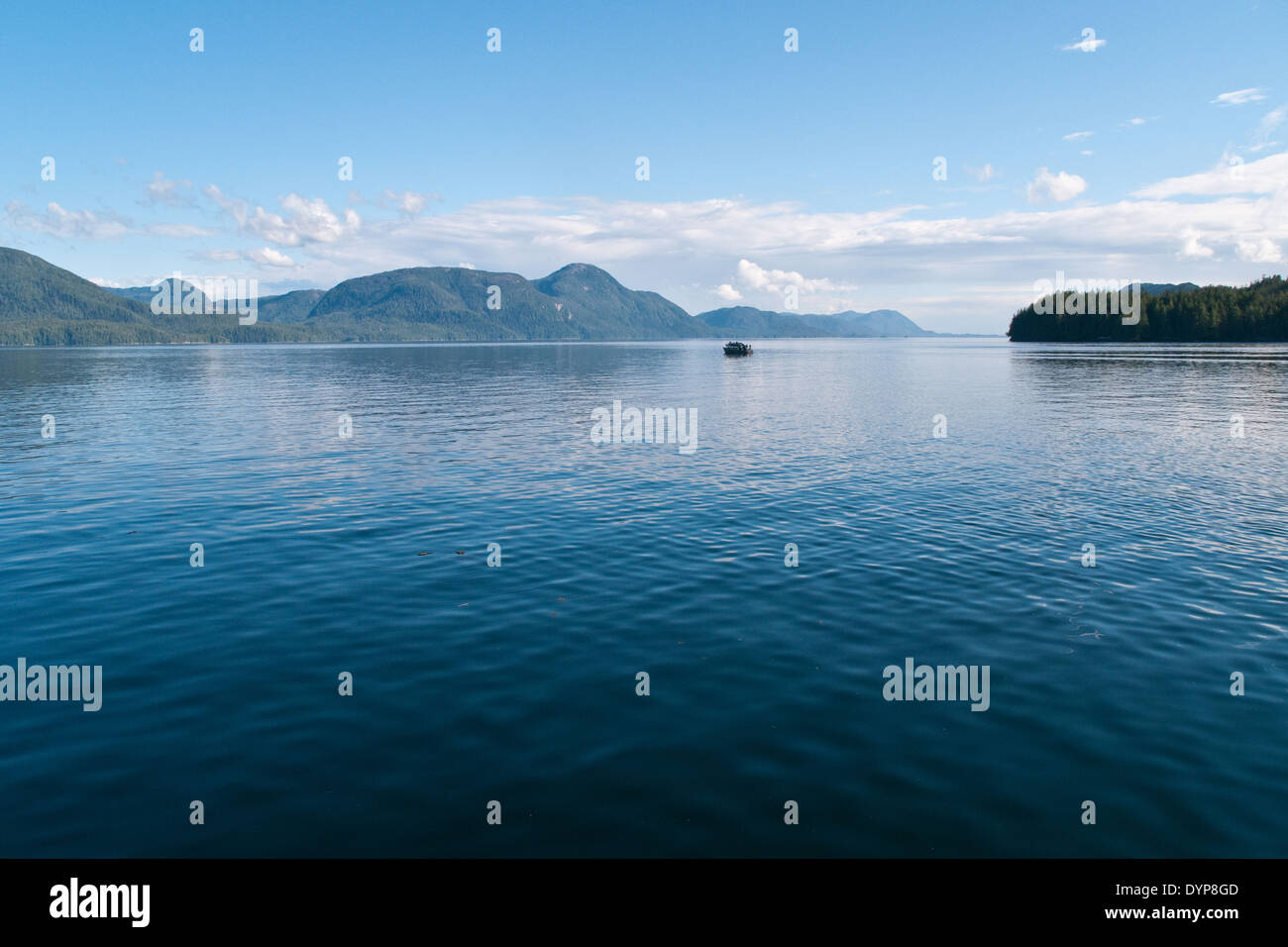 A small boat sits in a Pacific channel on a clear day near Klemtu, in ...