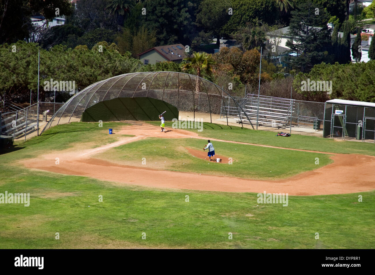 Father pitching baseball to son in park Stock Photo