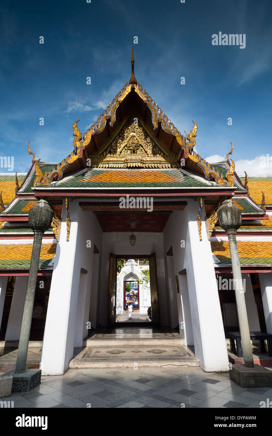 Thai temple, a walkway at Wat Suthat, Bangkok, Thailand, taken againt a blue sky. Stock Photo