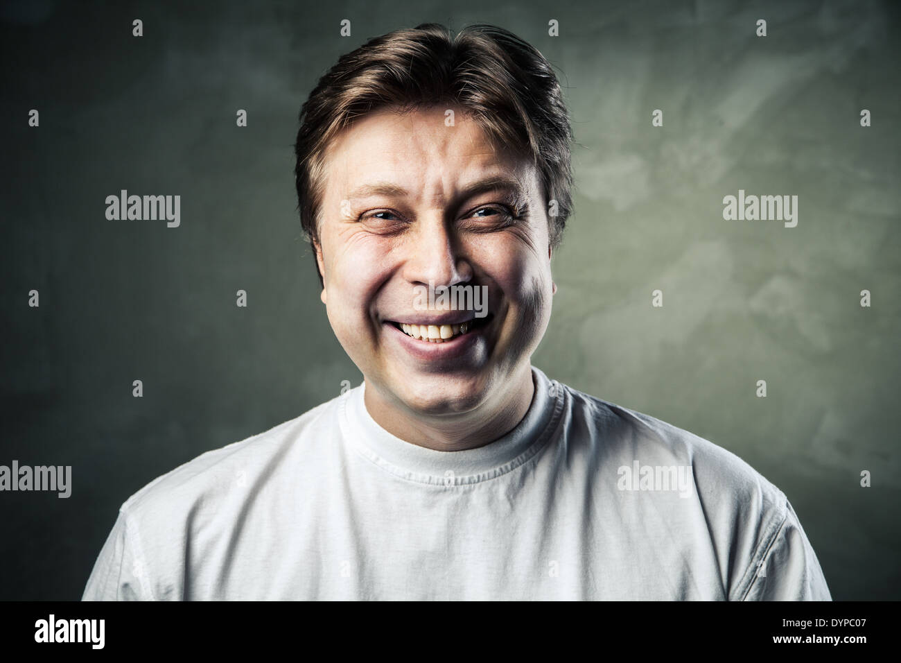 Laughing young man over gray texture background Stock Photo