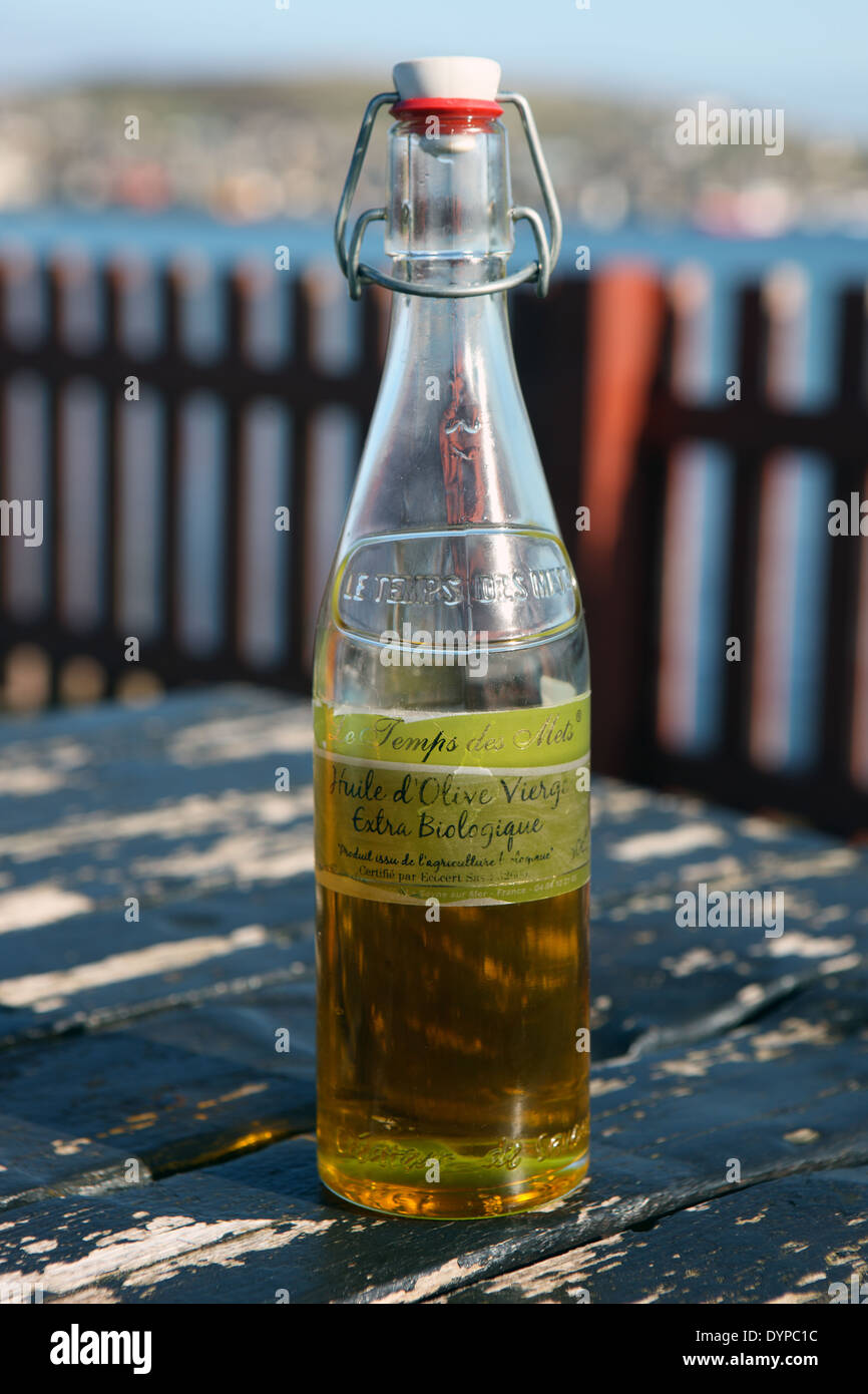 Bottle of Olive Oil on a picnic bench outside Stock Photo