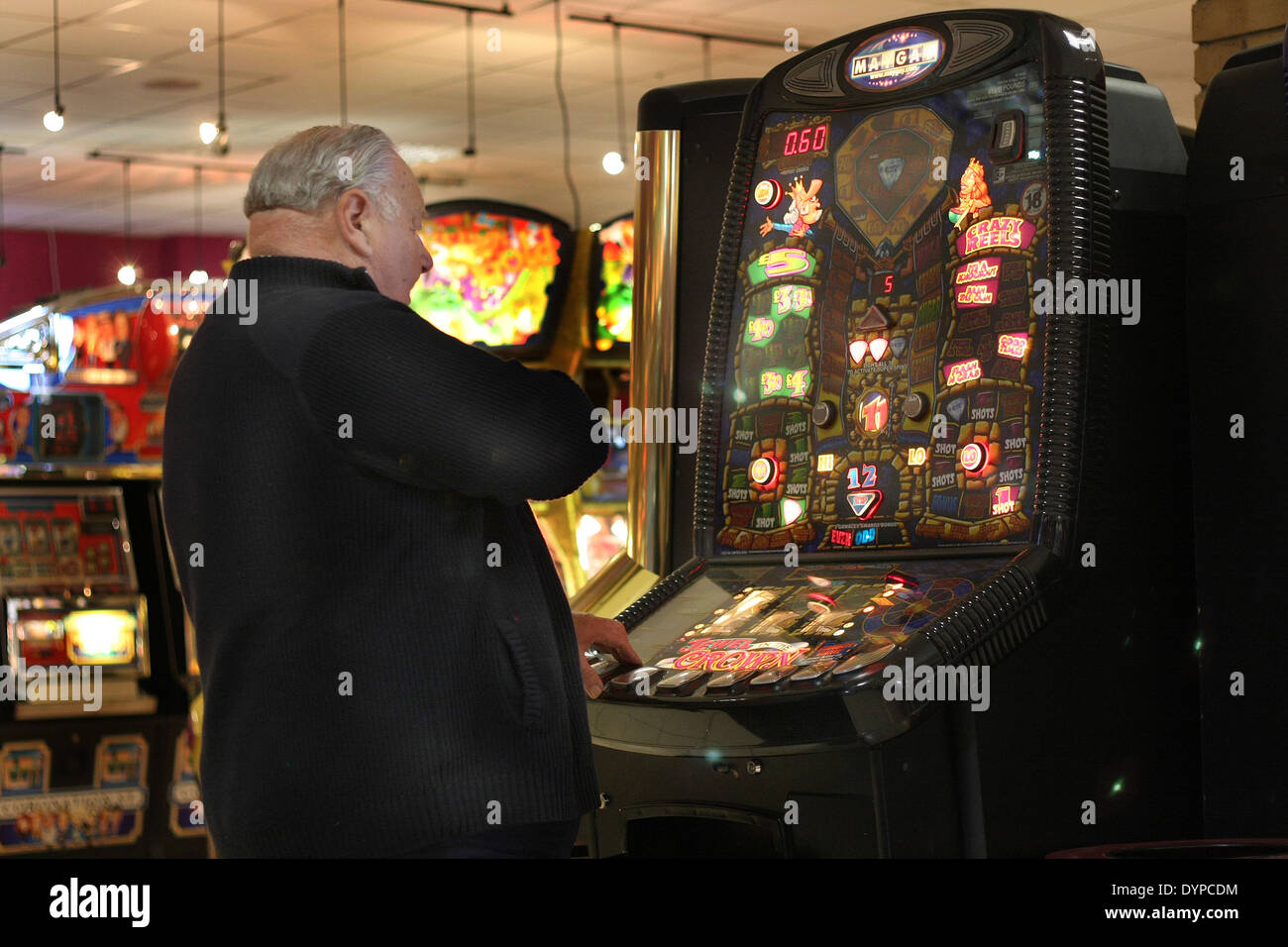 Man betting on gambling machine in amusement arcade. Stock Photo