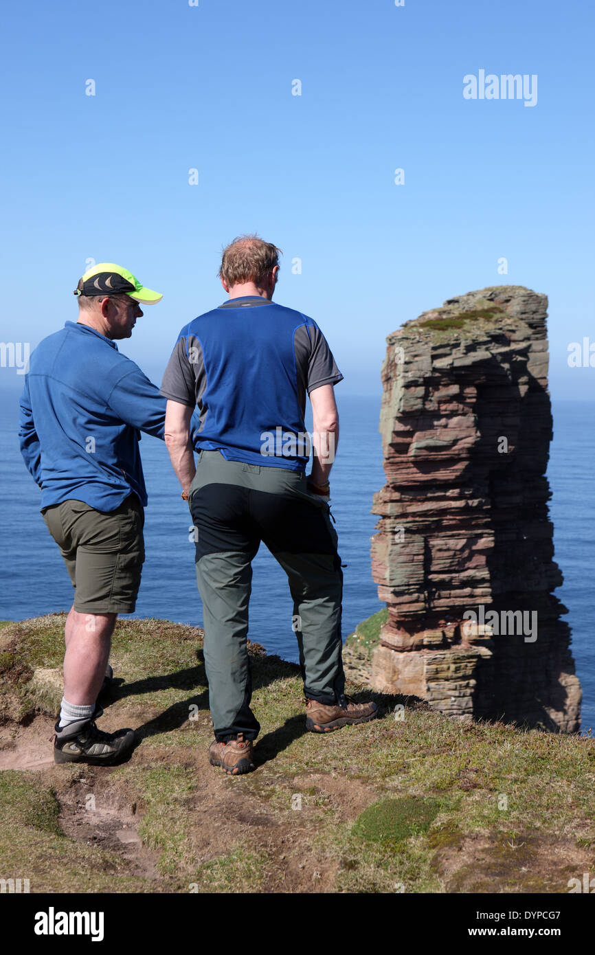 Men discussing the climbing route up the Old Man of Hoy, the red sandstone stack in Orkney Stock Photo