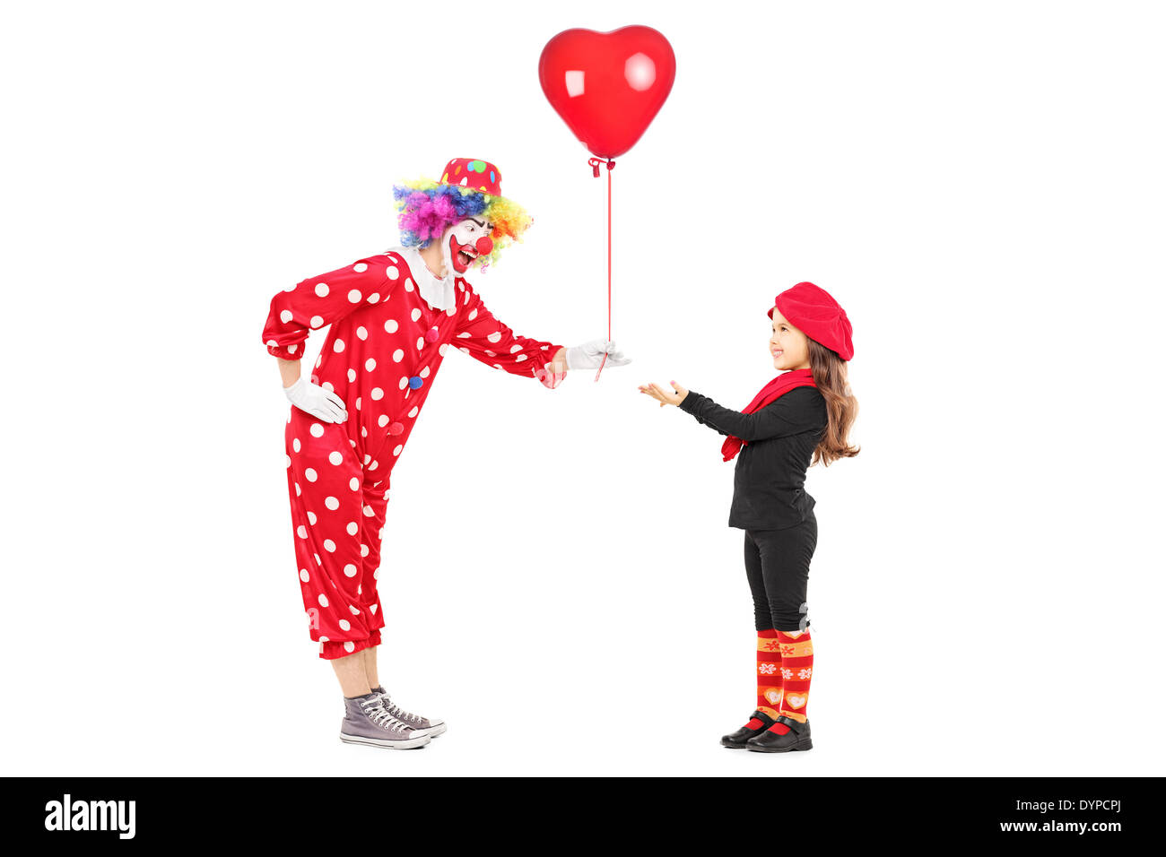 Male clown giving a red balloon to a little girl Stock Photo