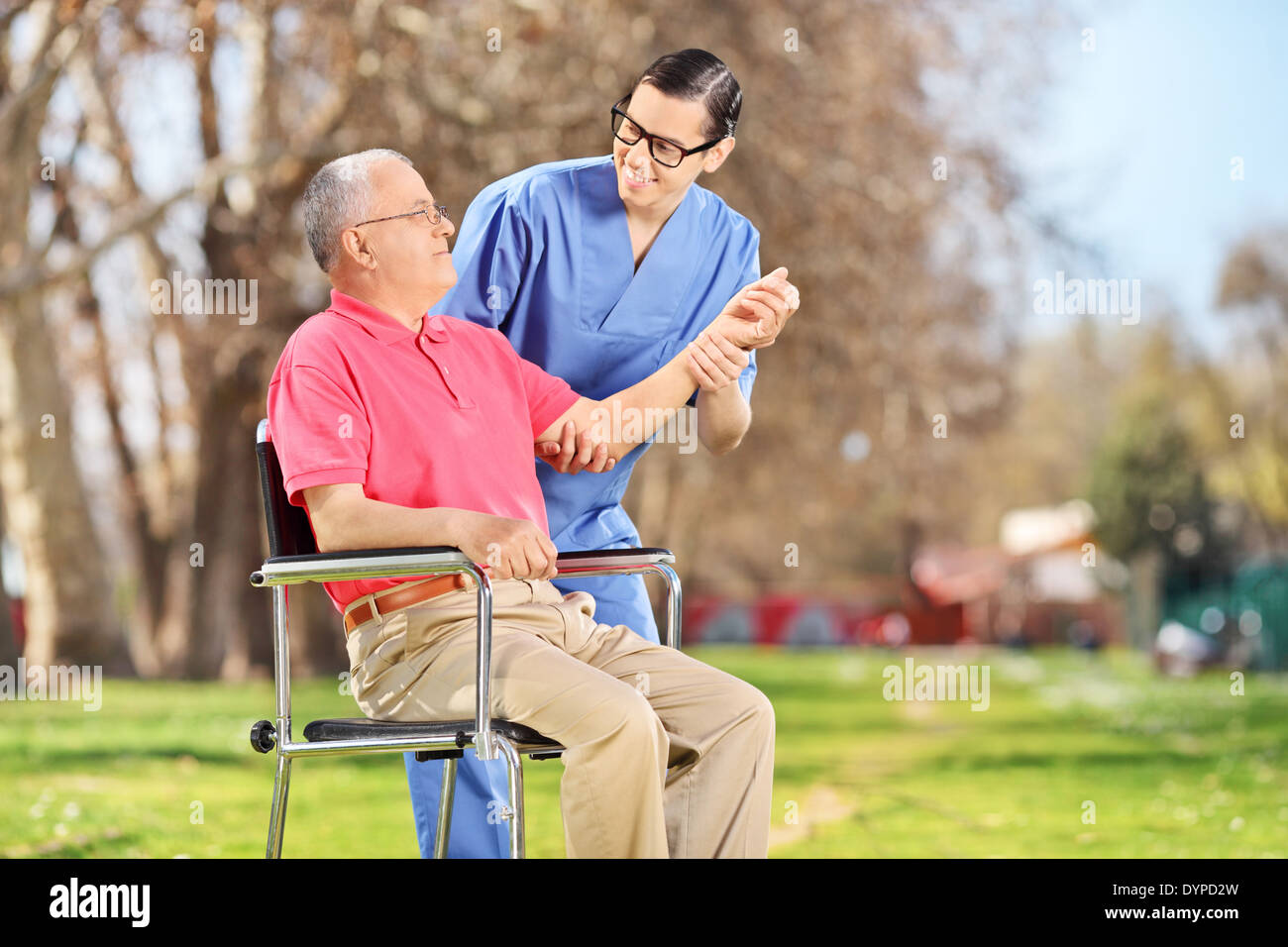 Male nurse checking the pulse of a senior in park Stock Photo