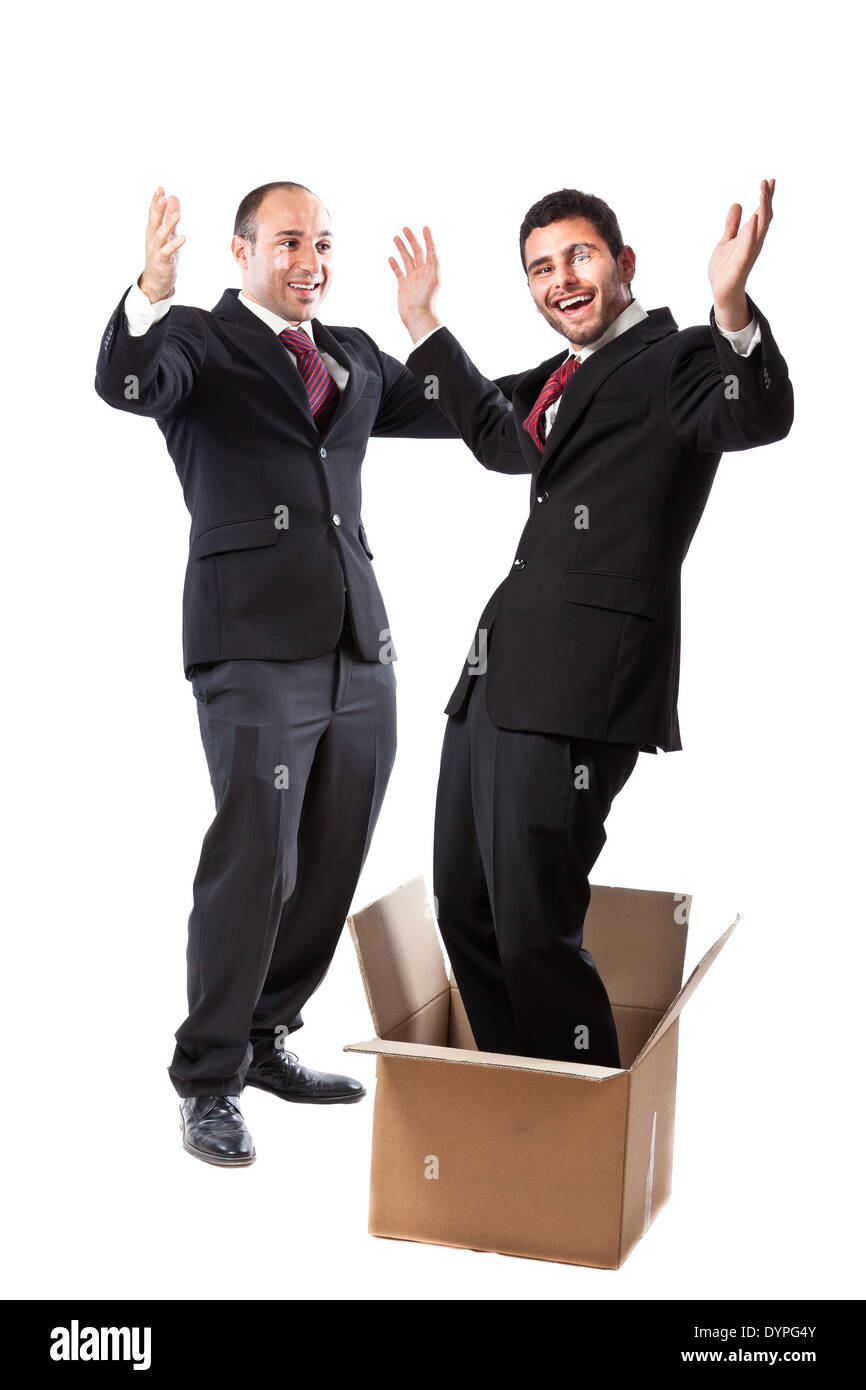 Two Businessmen standing on a white background; one of them is popping out of a box Stock Photo