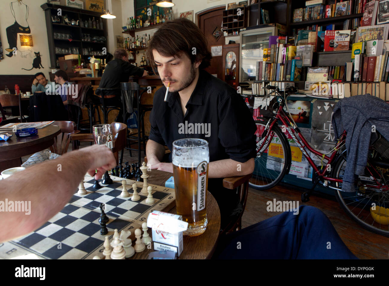 Prague bar inside Man play chess in Cafe Rybka Prague Czech Republic Young man alone in bar Stock Photo