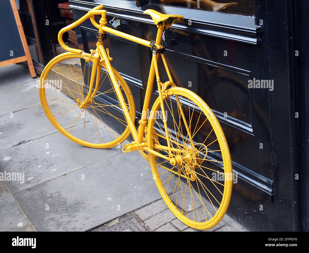 photo of old yellow bike on the window of the coffe shop Stock Photo