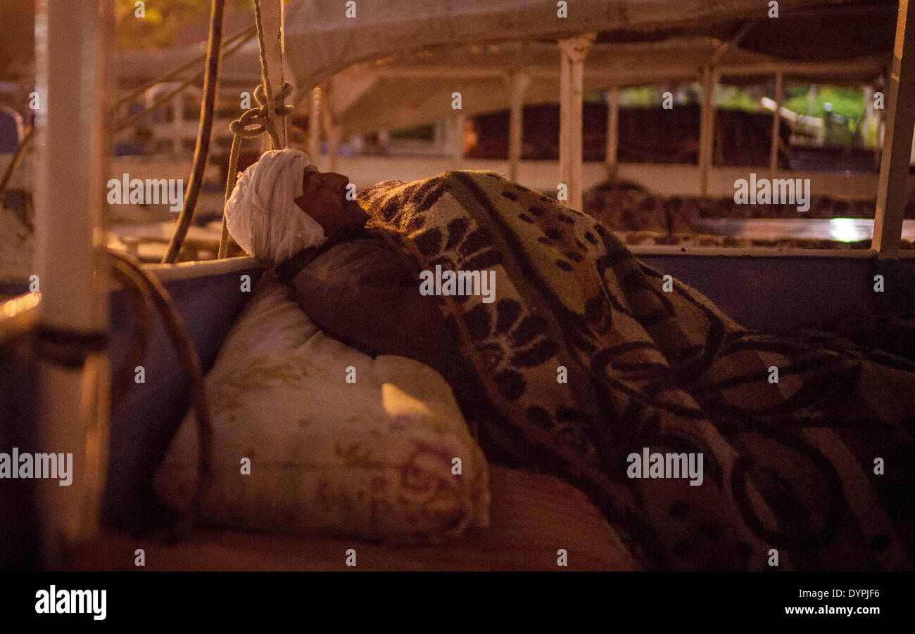 (140424) -- CAIRO, April 24, 2014 (Xinhua) -- Boatman Shaaban sleeps on a sailboat at a dock by the Nile River in Maadi district, Cairo, capital of Egypt, on March 18, 2014. The Yamama family from Giza has lived on the Nile River for nearly one century. Presently Abdel Majid and his brother Abed Rabbo run the sailboat business for tourists at a dock in Maadi district of Cairo. The Yamama brothers and the boatmen they hire have seen a dramatic drop on business as a result of the depression in tourism since 2011, when the Revolution began throughout the country. (Xinhua/Pan Chaoyue) (djj) Stock Photo