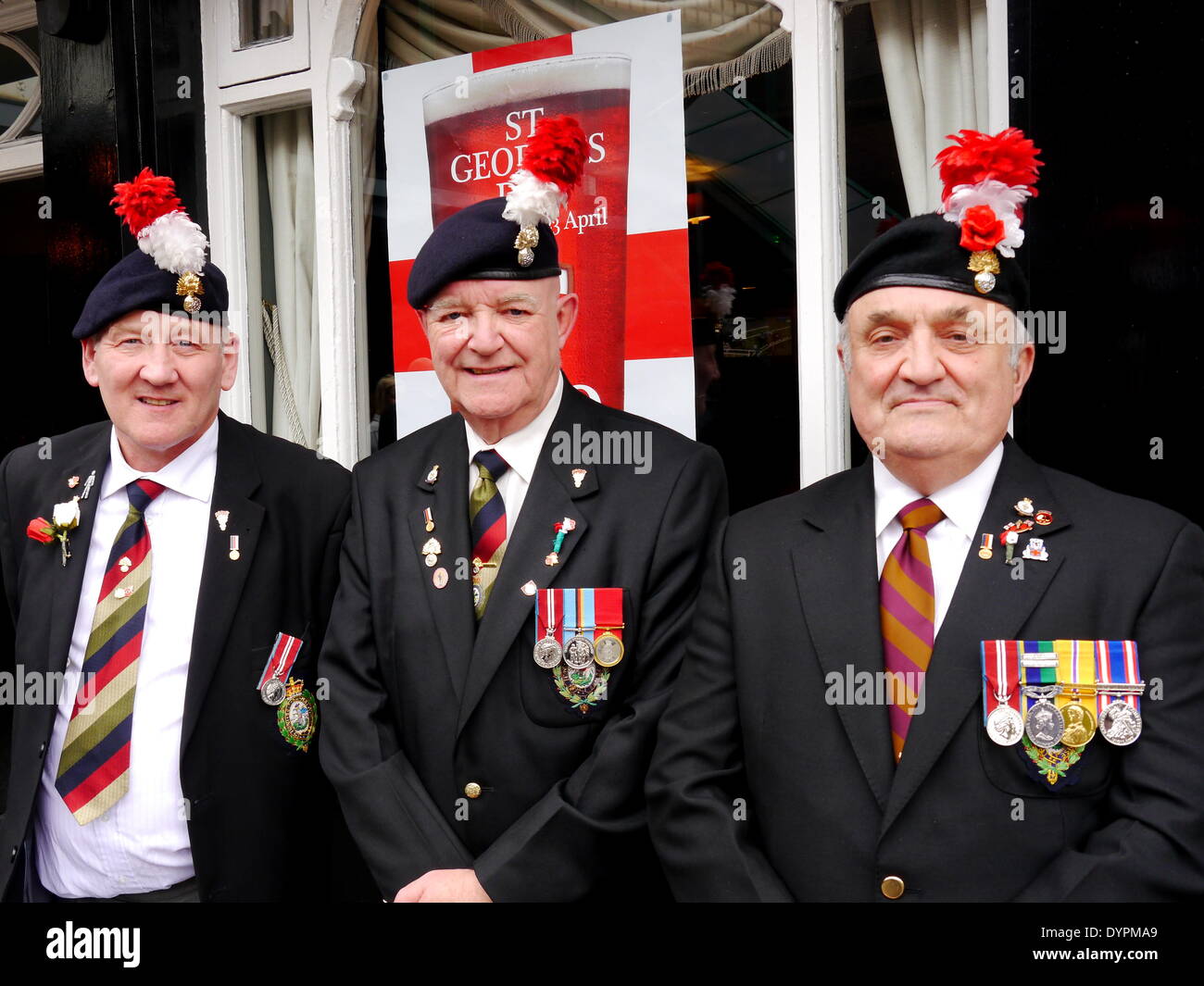 Newcastle upon Tyne, England, UK.  23rd April, 2014.   Royal Regiment of Fusiliers' veterans, Les Farthing, Carl Robinson & Alan Tweddle (L-R), celebrate  St. Georges's day at the Black Bull public house, Percy Street, Newcastle upon Tyne. Prior to that, on each St, George's day, they lay a wreath at the Church of St, Thomas the Martyr, Haymarket, Newcastle, to commemorate their fallen Fusilier comrades,  Proud to be in England.  Credit:  Victor W. Adams / Alamy Live News Stock Photo