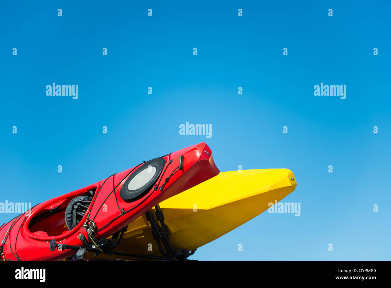 Red and yellow kayaks on blue sky. Stock Photo
