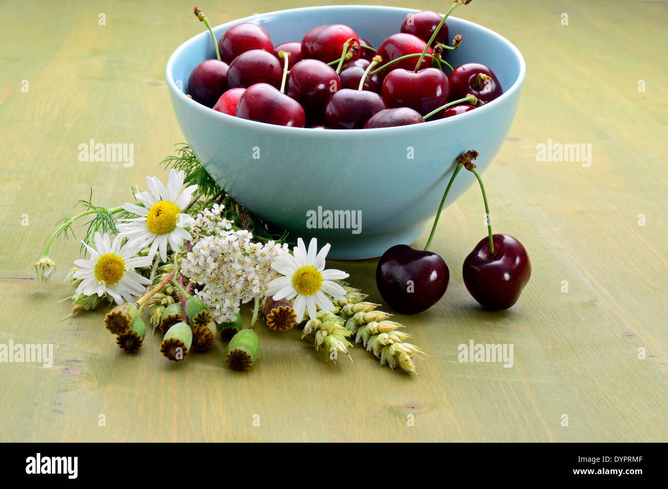 Fresh harvested cherries in a bowl on a wooden table Stock Photo
