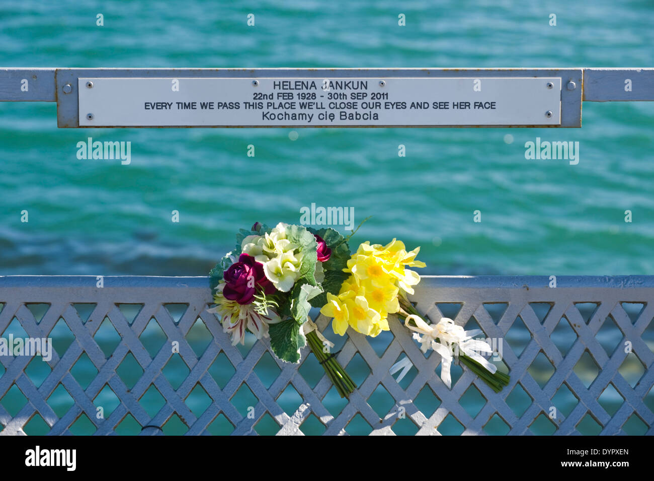 Memorial plaques with flowers on Bangor Pier on the Menai Strait at