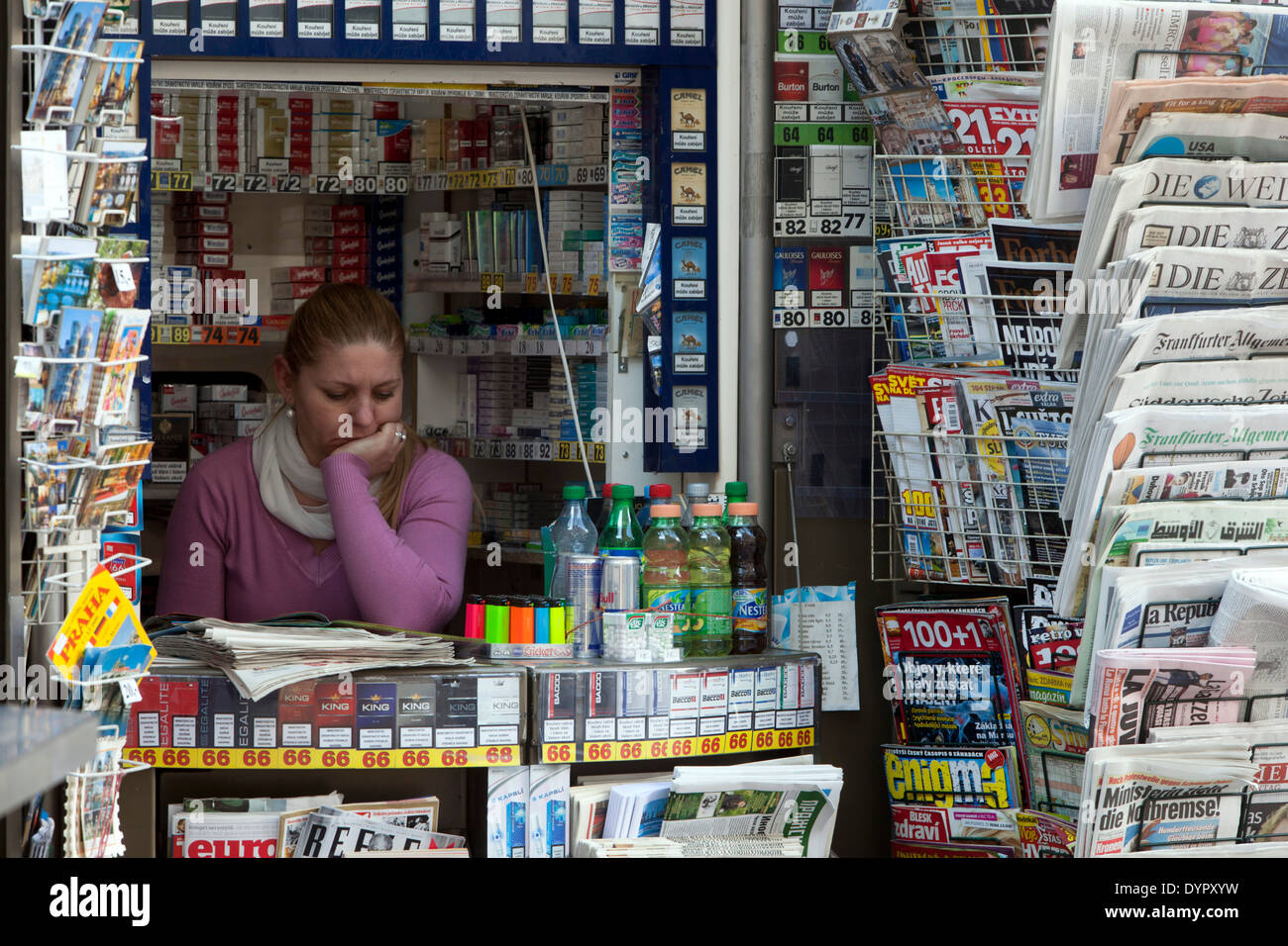 Saleswoman in a newspaper stand with world magazines and newspapers Prague stall Stock Photo
