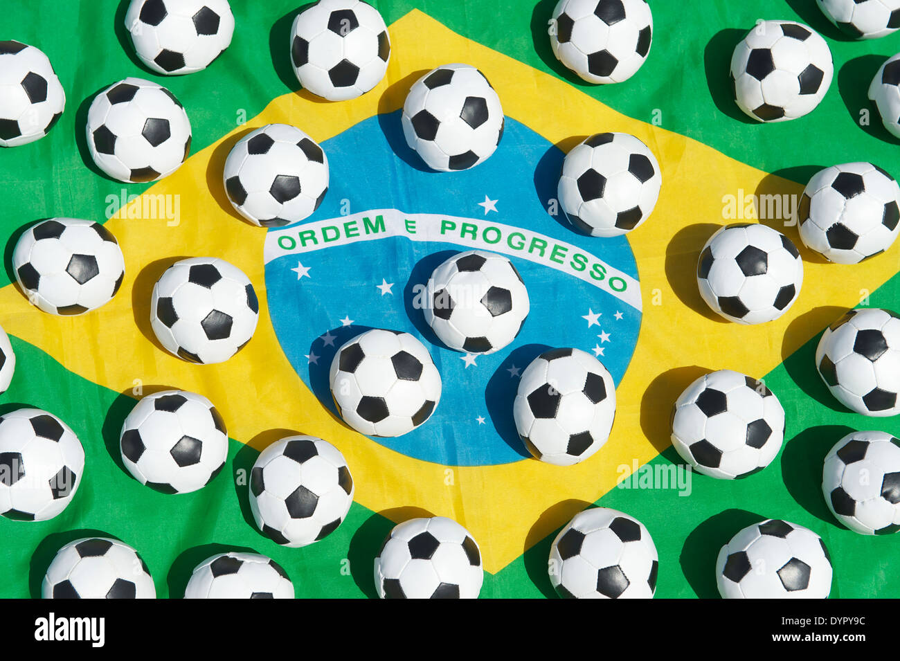 Brazil flag with many small football soccer balls in outdoors in bright