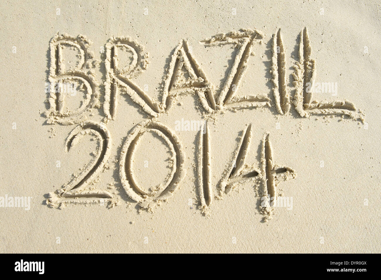 Brazil 2014 handwritten message on bright sunny smooth Brazilian sand beach Stock Photo