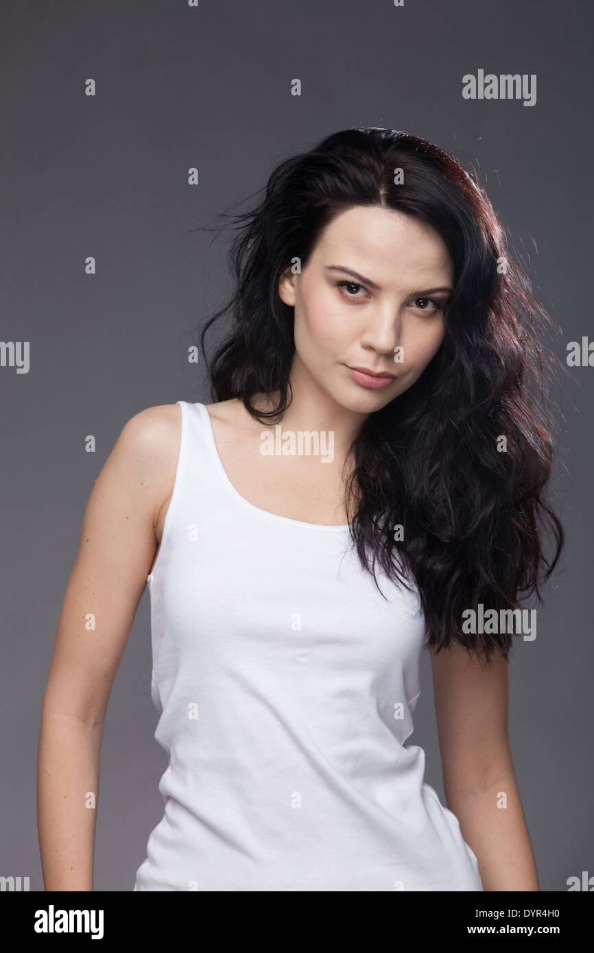 color image, portrait style, of a Caucasian girl with black hair wearing a  white tank top Stock Photo - Alamy