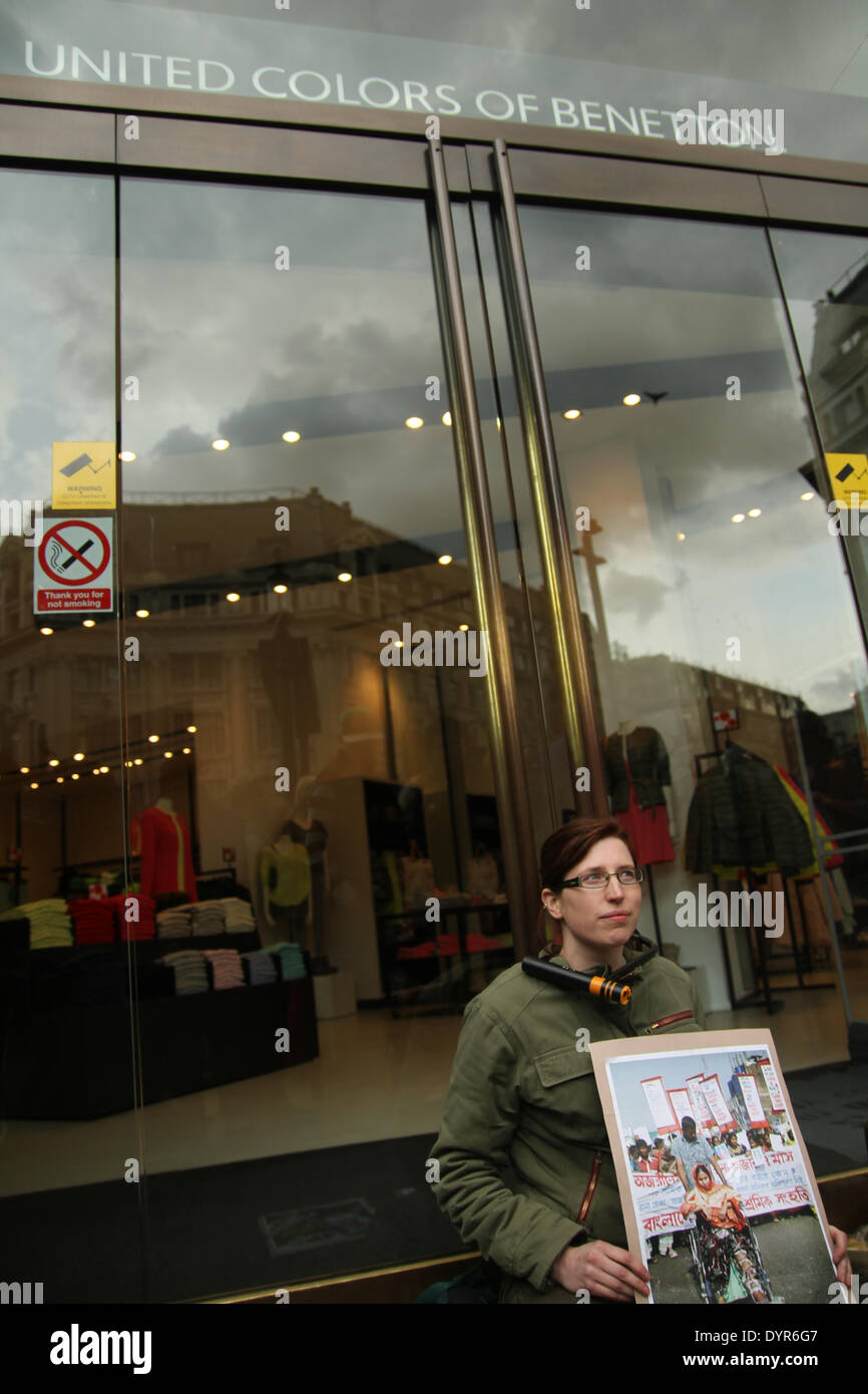 London, UK. 24th April 2014. A protestor with her necked chained on the glass doors of the Oxford Street store. Credit:  david mbiyu/Alamy Live News Stock Photo