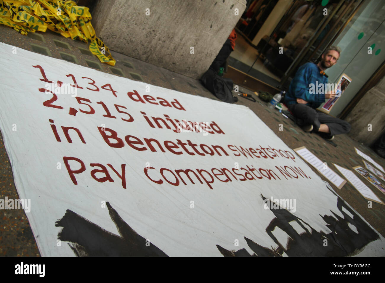 London, UK. 24th April 2014. A large banner seen between the two chained protesters outside The Benetton store on Oxford Street Credit:  david mbiyu/Alamy Live News Stock Photo