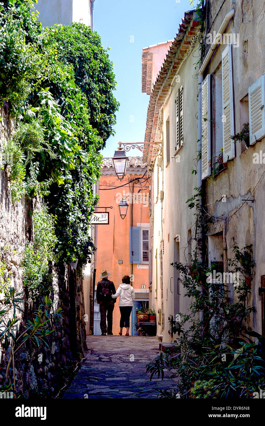 Europe, France, Var. Ramatuelle. Couple walking in a Typical alley in the village. Stock Photo