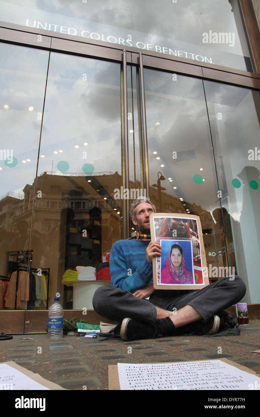 London, UK. 24th April 2014. Two protesters chained their necks on the doors of the Benetton shop on Oxford street. The protest began at 8.30am. The protest comes on the first anniversary of the Rana Plaza garment factory collapse in Bangladesh where 1,134 people lost their lives. Credit:  david mbiyu/Alamy Live News Stock Photo