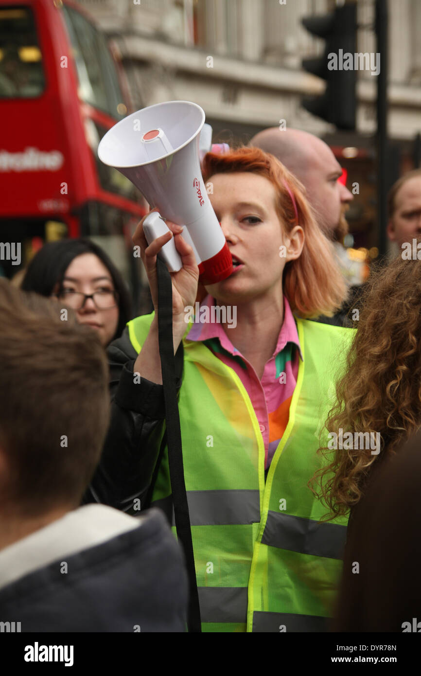 London, UK. 24th April 2014. A woman talks through a megaphone as  group of protesters carrying a banner with the words 'Inside Out' chant 'Who made your clothes' Credit:  david mbiyu/Alamy Live News Stock Photo