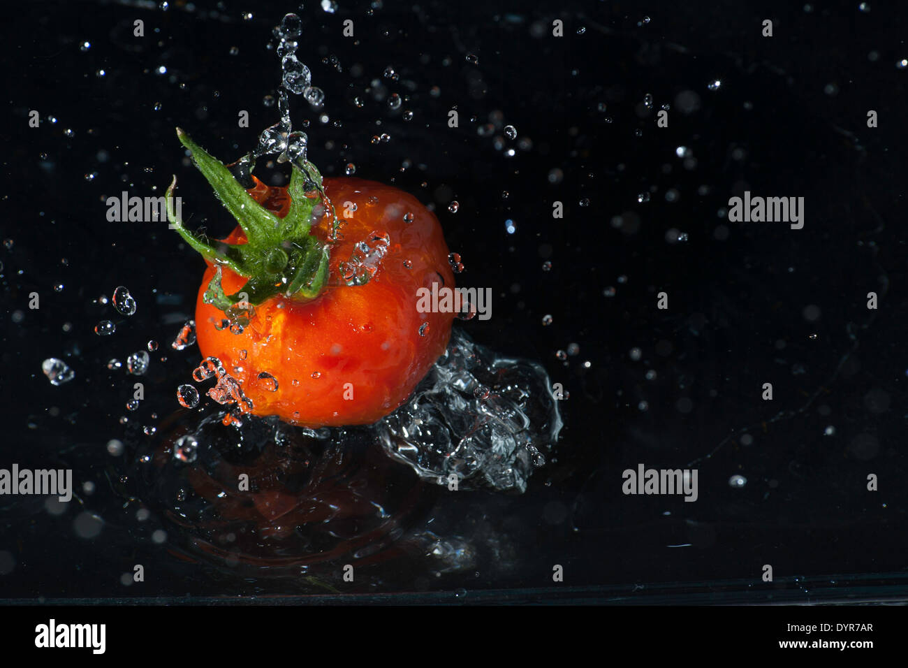 Red Tomato Dropped In Water Stock Photo
