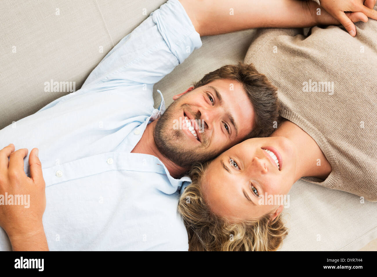 Happy young couple at home relaxing on the sofa Stock Photo
