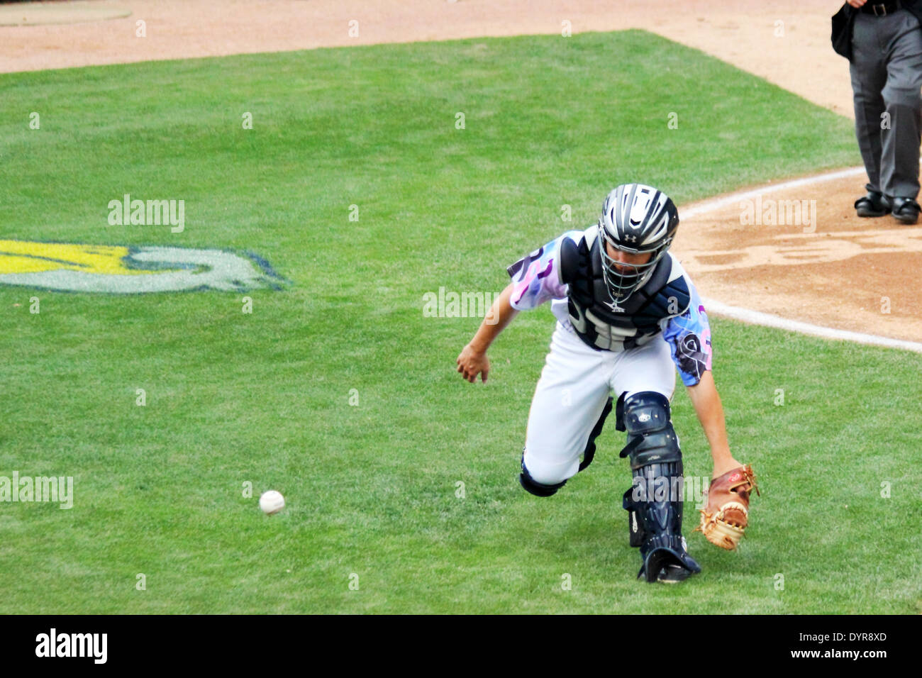 A baseball catcher chases a wild pitch. Stock Photo