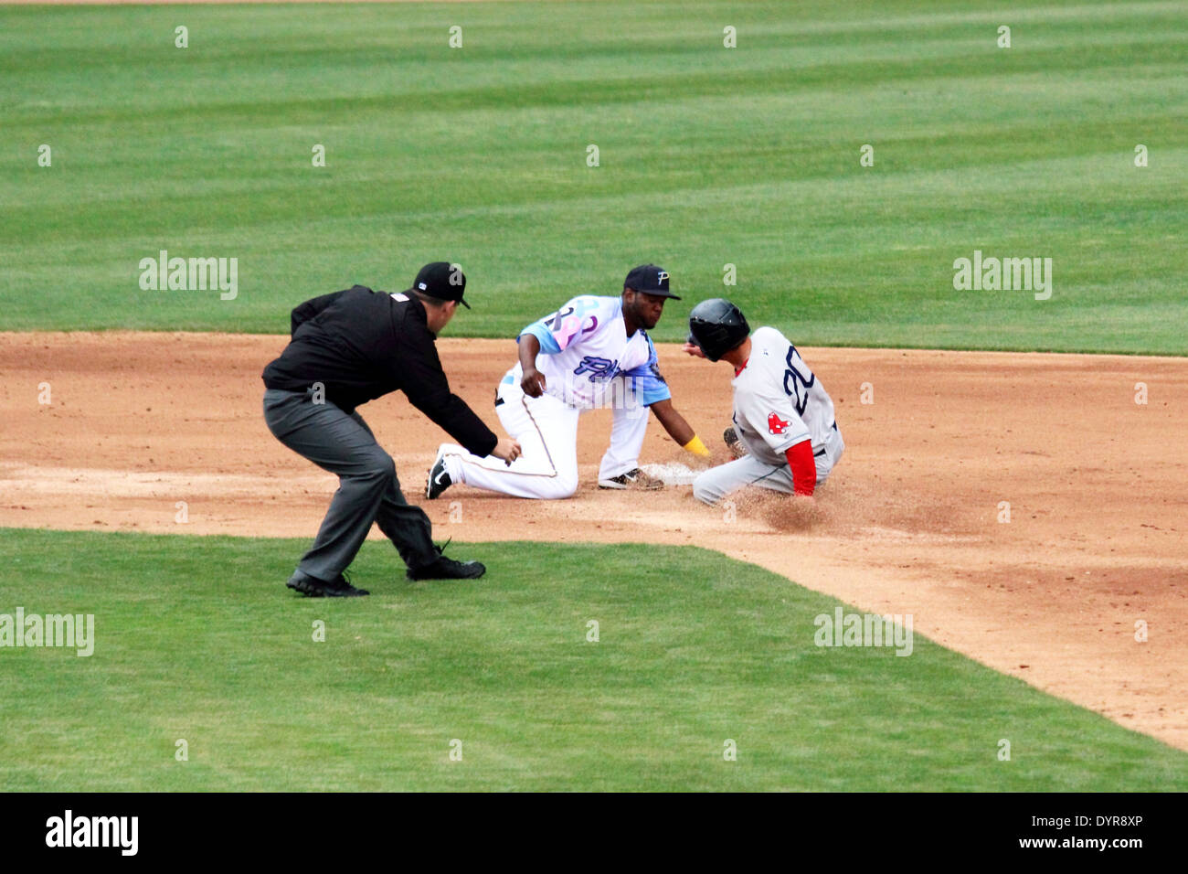 A runner slides into second attempting to steal second base. Stock Photo