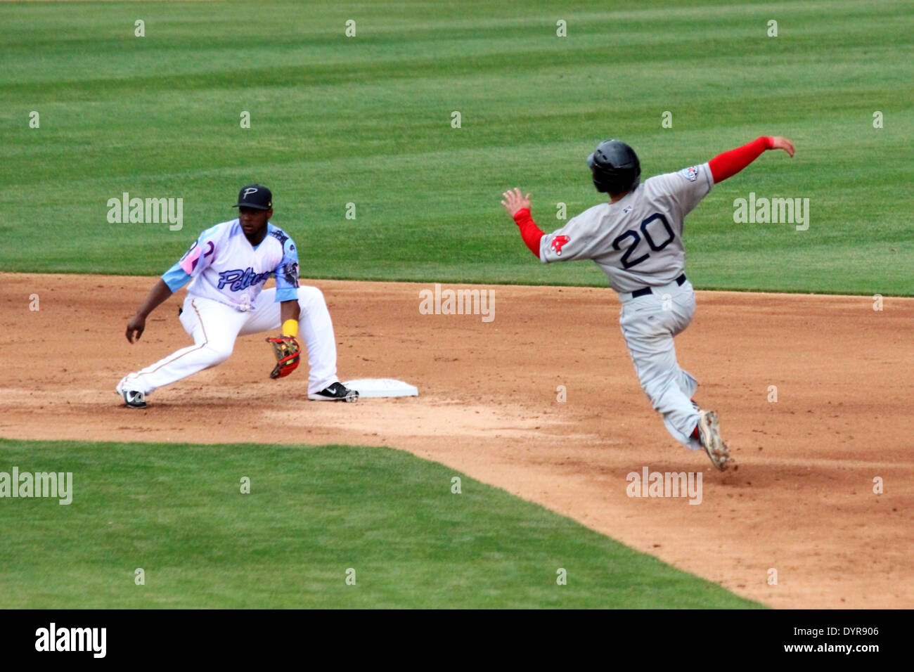 A runner begins a slide into second attempting to steal second base. Stock Photo