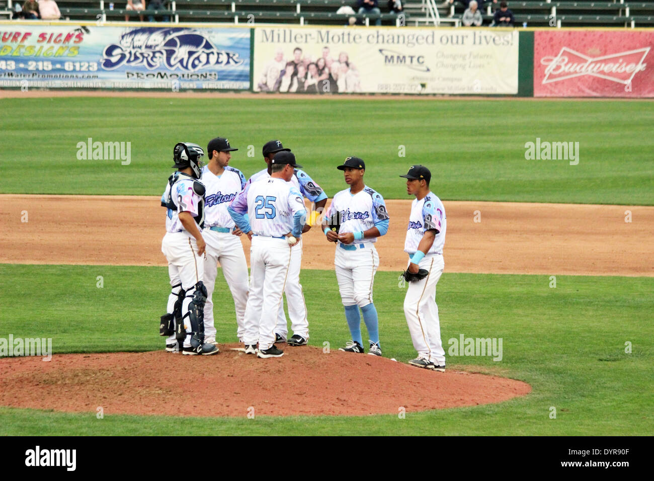 Baseball players meet on the pitchers mound Stock Photo
