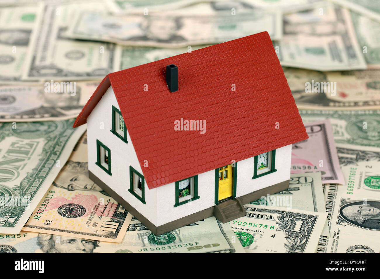 Symbol for home financing with a house on Dollar notes Stock Photo