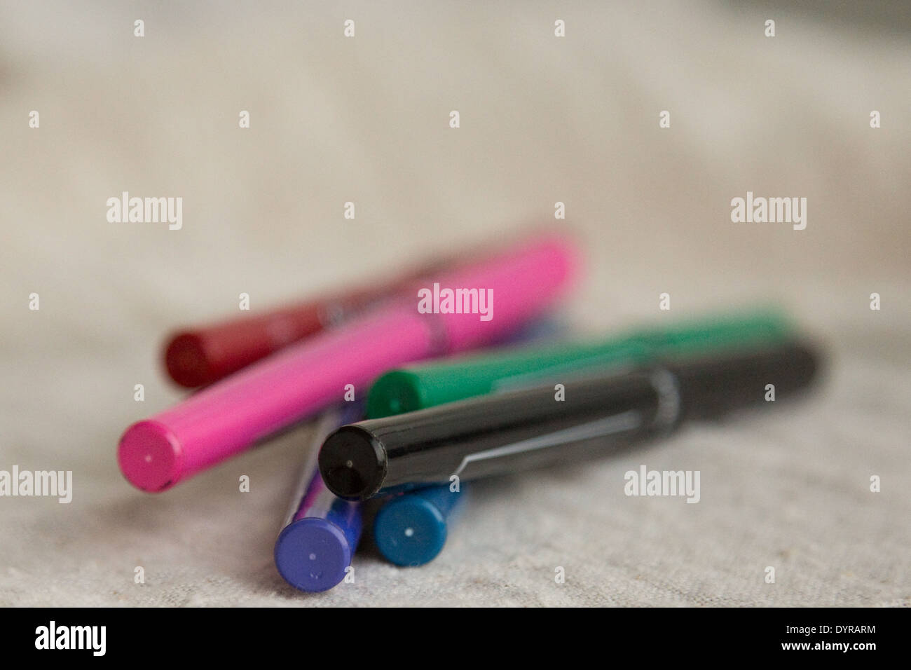 stack of colorful pens on linen background Stock Photo