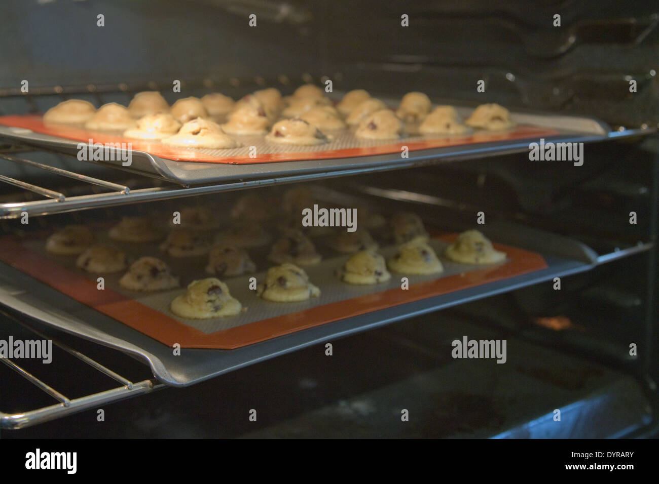 gluten free cookie dough cooking on baking trays in oven Stock Photo
