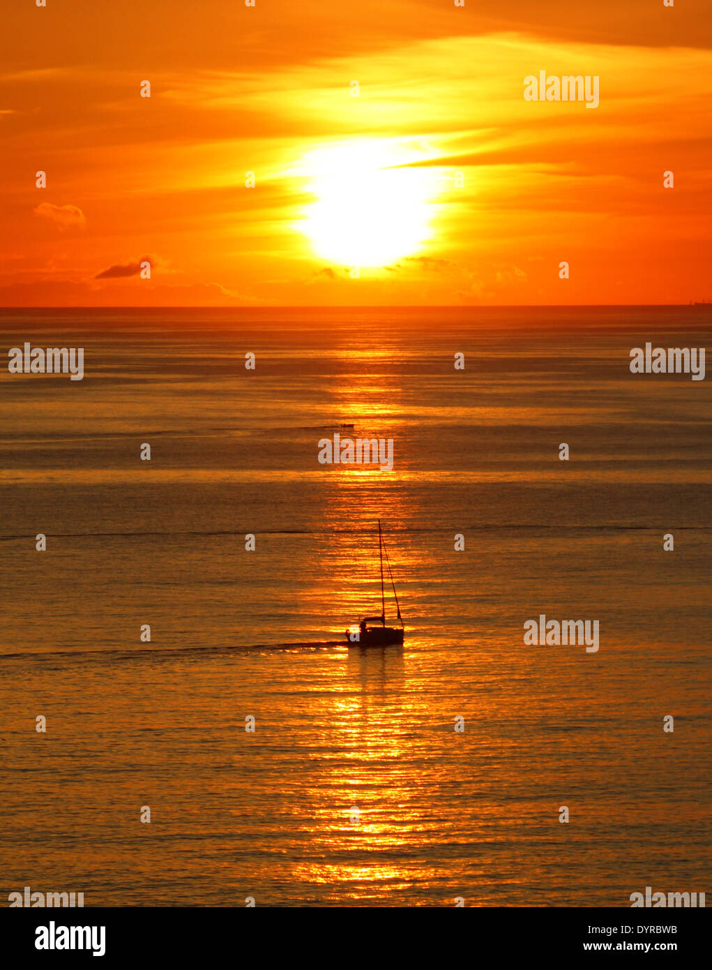 Sunrise at sea in Las Palmas de Gran Canaria, Spain, with a sail boat  silhouette in sunlight streak in the water Stock Photo - Alamy