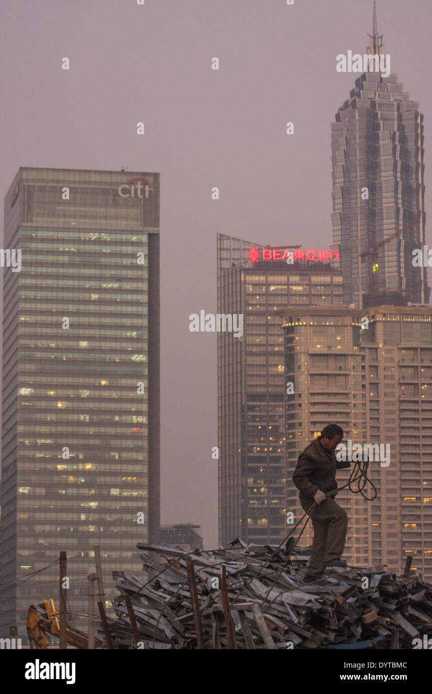 A worker stand on scrape metal at a construction site at the Bund with Pudong Financial district in background Stock Photo