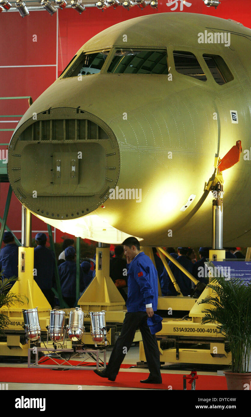 A man walks on front of a ARJ-21's aircraft at Shanghai Aircraft Manufacturing Factory in Shanghai Stock Photo