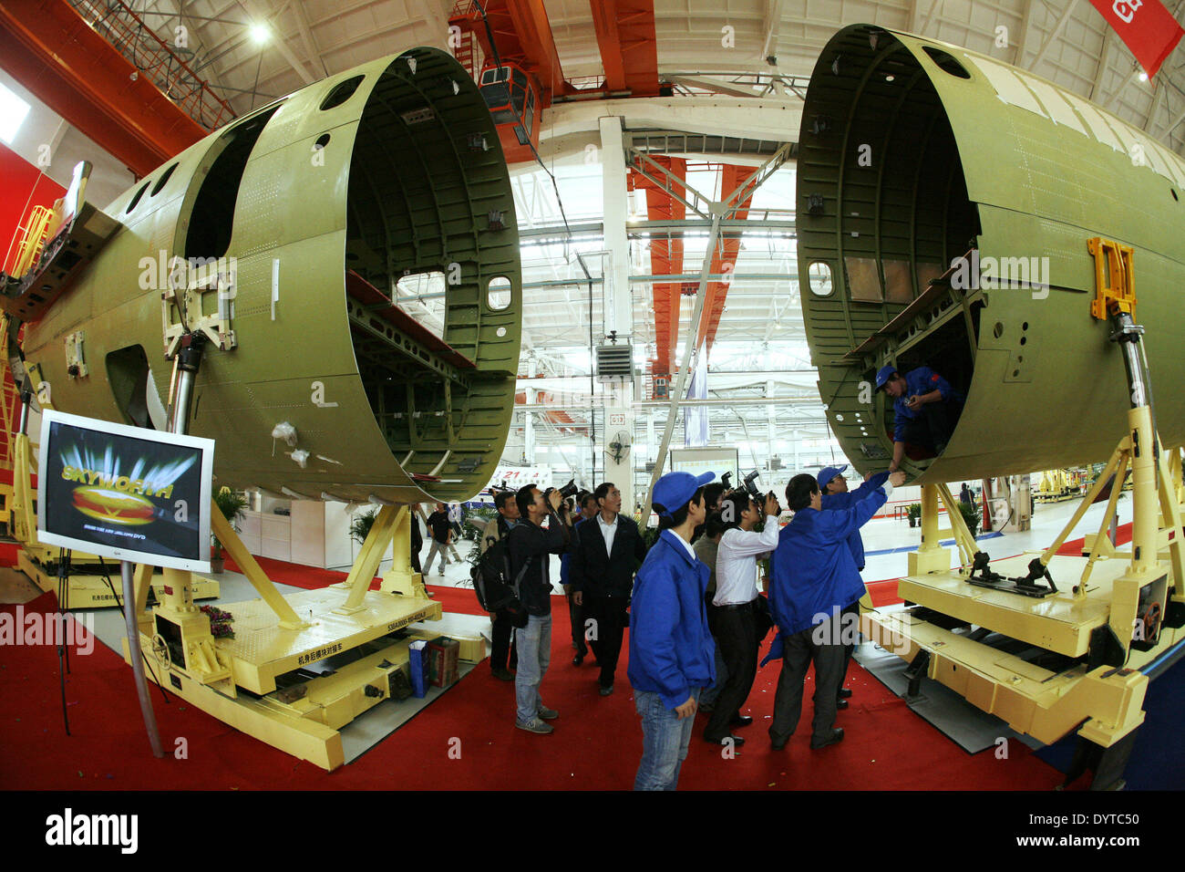 Chinese visitors look at a ARJ-21 aircraft at a assembly line of Shanghai Aircraft Manufacturing Factory in Shanghai Stock Photo