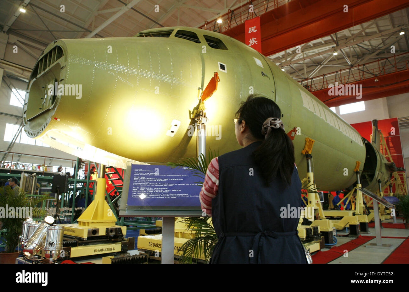A Chinese woman looks at a ARJ-21 jet at Shanghai Aircraft Manufacturing Facilityassembly facility in Shanghai Stock Photo
