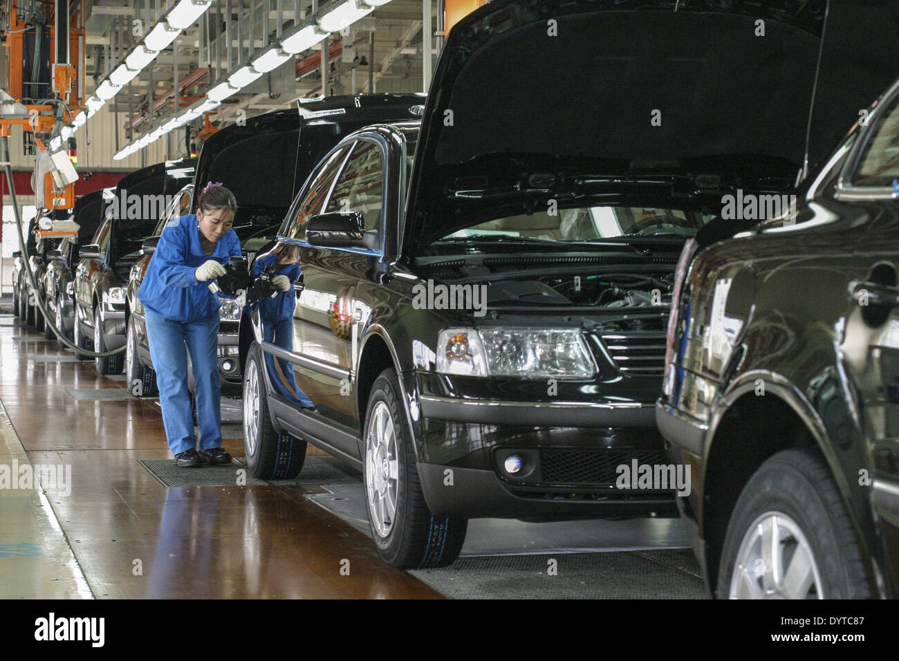 A worker fuels up a Volkswagen Passat at the end the production line at Shanghai Automotive Industries Corp Stock Photo
