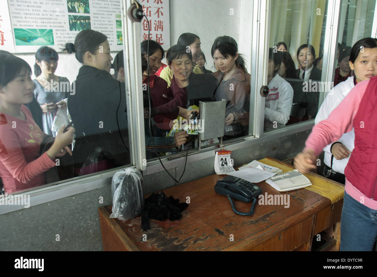 Workers check out with their cards at the Jiangsu Sunshine Co Stock Photo