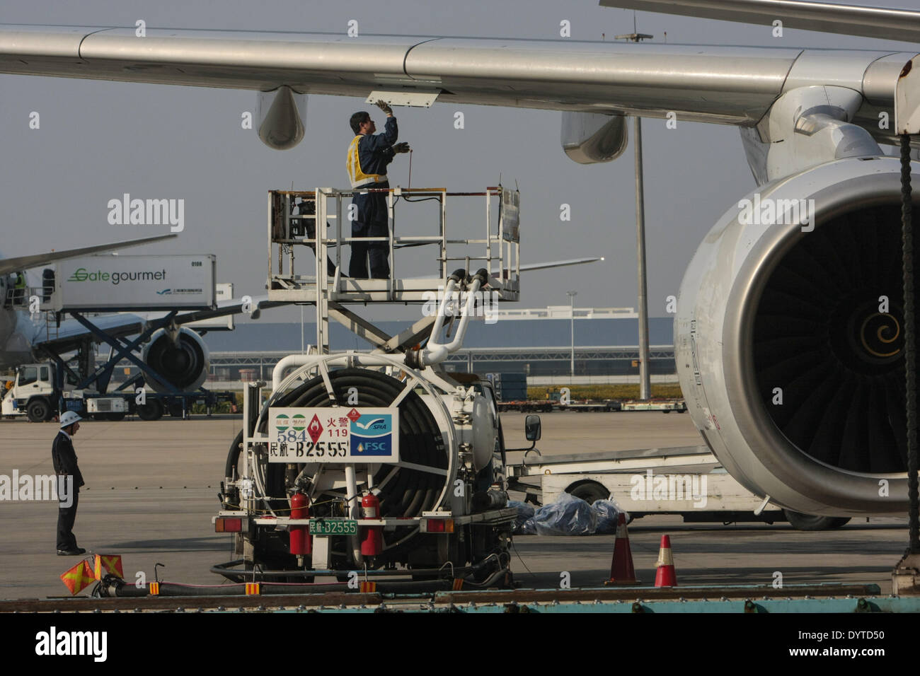 Airport technician fill up gas for a plane at Shanghai Pudong International Airport on 22 Nov 2007 Stock Photo