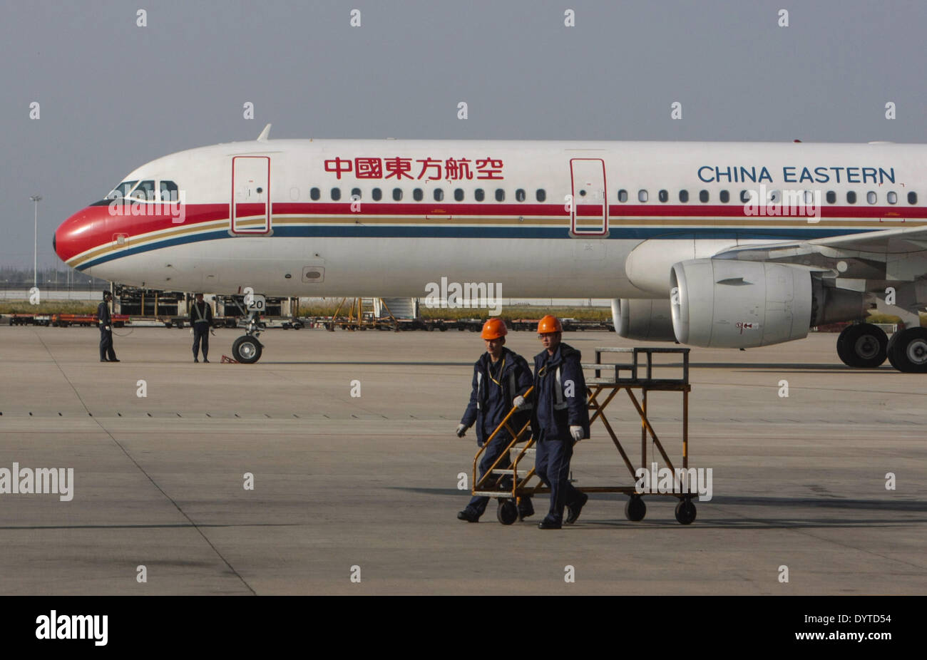 Airport staff walk pass a plane of China Eastern Airline at Shanghai Pudong International Airport on 22 Nov 2007 Stock Photo