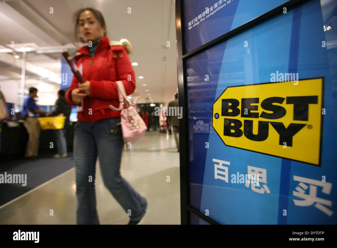 A Woman Pass By A Best Buy Sign Inside A Best Buy Store In